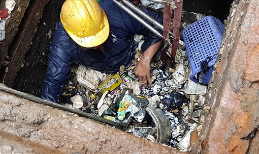 Rác thải lấp đầy miệng cống thu nước về siêu máy bơm khiến đường Nguyễn Hữu Cảnh bị ngập nhẹ trong cơn mưa trưa nay (17.10). Ảnh: Trường Sơn