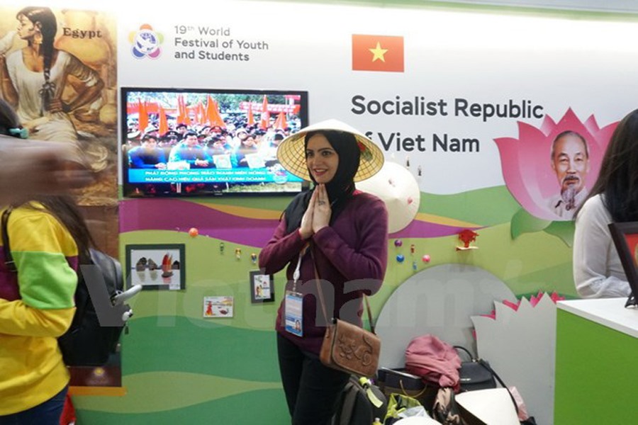 Các bạn trẻ thích thú với trang phục của 54 dân tộc Việt Nam. Ảnh:Vietnam+