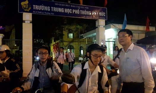 Dù đã tối muộn nhưng thầy Nguyễn Quốc Bình vẫn đứng ra tận cổng trường chào, dặn dò các em học trò đi đường cẩn thận để về nhà. Ảnh: ĐT