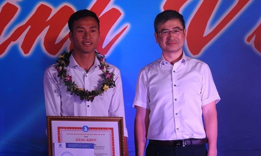 Em Vũ Huy Cảng (bìa trái) được Hiệu trưởng Đại học Điện lực Trương Huy Hoàng tặng thưởng vào tối ngày 25.10. Ảnh: HH.