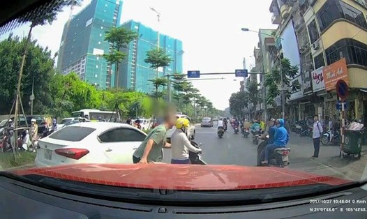 Người lái xe buộc phải xuống xe kéo người phụ nữ và xe vào lề đường để tiếp tục lưu thông. Ảnh cắt từ clip