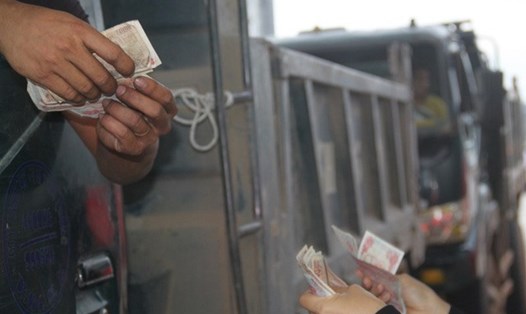 Tài xế dùng tiền 500 đồng để mua vé qua trạm thu phí Nam Bình Định. Ảnh: Dân trí
