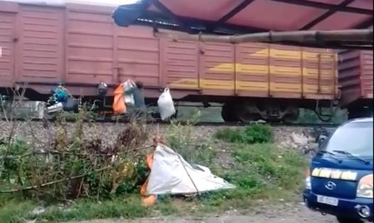 Hình ảnh người dân thị trấn Hương Khê treo những bao rác lên tàu hỏa. Ảnh cắt từ clip trên faceboook