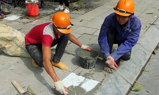 Công nhân vá lại vỉa hè ở đường Nguyễn Trãi.