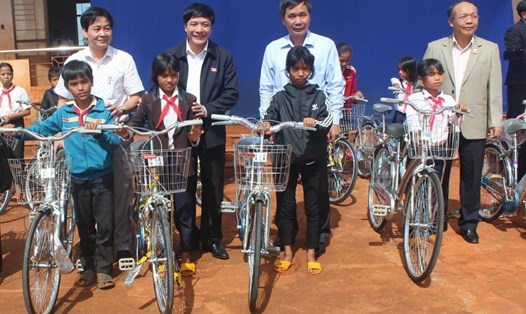 Trước cuộc tiếp xúc cử tri, Đại biểu Quốc hội - Chủ tịch Tổng LĐLĐVN Bùi Văn Cường (thứ 2 từ bên trái) trao xe đạp cho các học sinh nghèo tỉnh Gia Lai. Ảnh: ĐÌNH VĂN