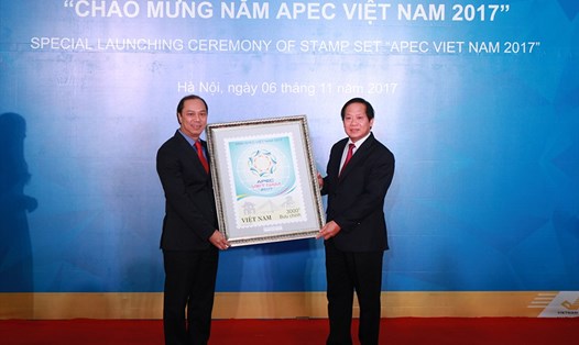 Bộ trưởng Bộ Thông tin và Truyền thông Trương Minh Tuấn trao bức tranh bộ tem cho Thứ trưởng Bộ Ngoại Giao Nguyễn Quốc Dũng tại buổi lễ.