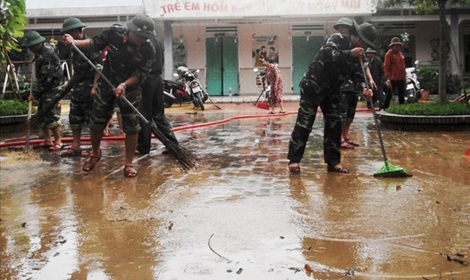 Các cán bộ, chiến sĩ của Ban CHQS huyện Đại Lộc tham gia dọn vệ sinh tại trường mầm non thị trấn Ái Nghĩa. Ảnh: LP