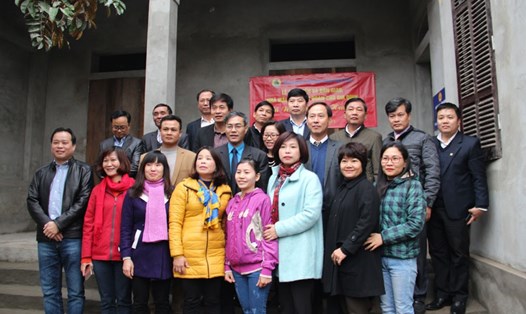 Các đại biểu và chị Nguyễn Thị Hường chụp ảnh lưu niệm trước ngôi nhà mới khánh thành. Ảnh: QUẾ CHI