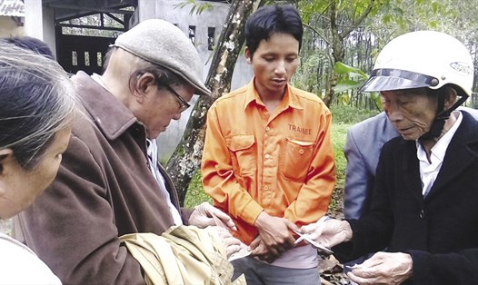 Anh Trọng Bá (đứng giữa), một trong bốn người con ông Nghĩa bên một số người bạn cũ của bố anh ở bên ngoài nhà xác Bệnh viện H.Hương Trà - Ảnh: Đ.T