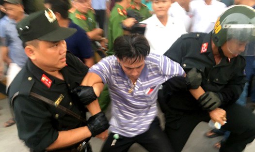 Tài xế Trịnh Hồng Phương bị công an áp giải đưa về đồn hôm 30.11.