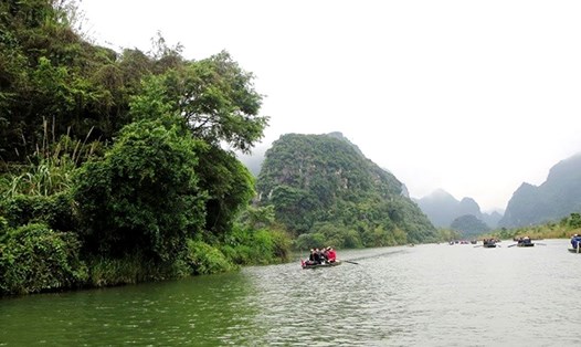 Du khách đi thuyền trên sông.
