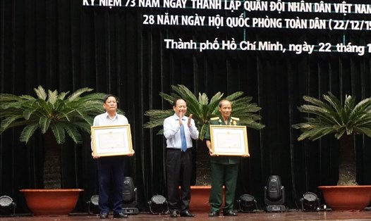 Phó Bí thư Thường trực Thành ủy TPHCM Tất Thành Cang trao Huân chương Độc lập hạng Ba cho sĩ quan cao cấp và gia đình sĩ quan cao cấp.   Ảnh: M.Q