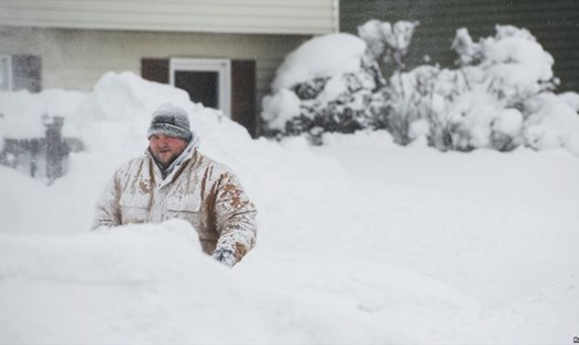 Một người dân dọn tuyết ở trước nhà ở Erie, Pennsylvania ngày 27.12. Ảnh: Reuters