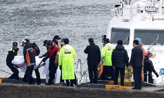 Lưc lượng chức năng mang thi thể của các nạn nhân trong vụ lật tàu lên bờ. Ảnh: AP/Yonhap