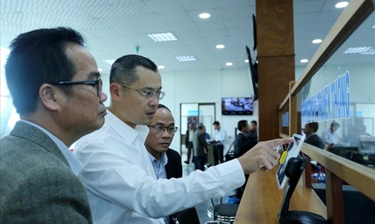 Thứ trưởng Phạm Đại Dương (giữa) kiểm tra thông tin điện tử tại điểm tiếp nhận hồ sơ và chuyển trả kết quả TTHC của tỉnh Gia Lai. Ảnh: PV