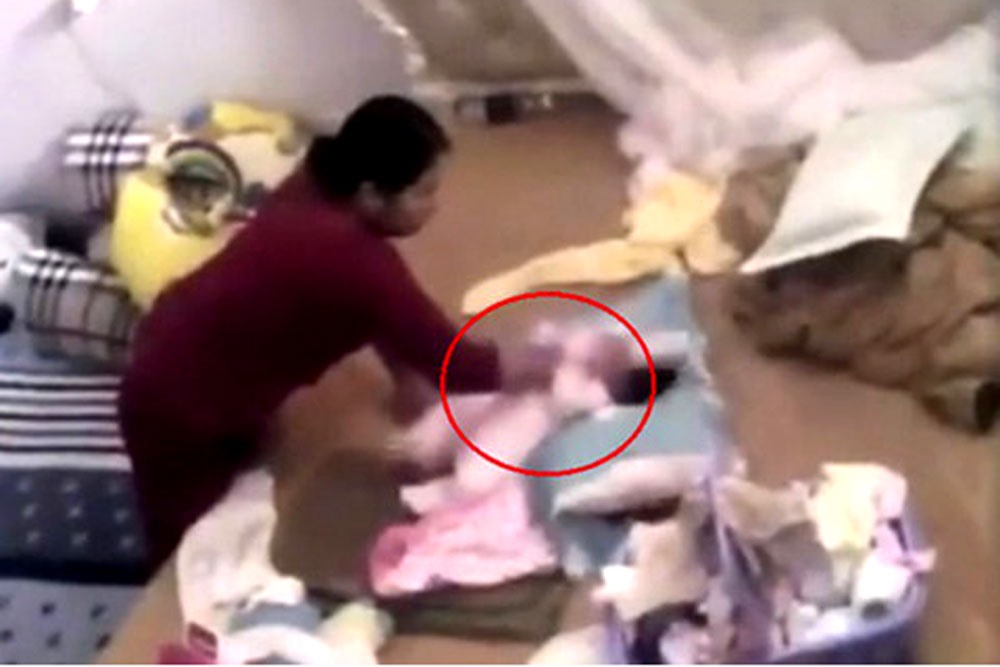 Bé gái gần 2 tháng tuổi bị bạo hành. Ảnh cắt từ clip.