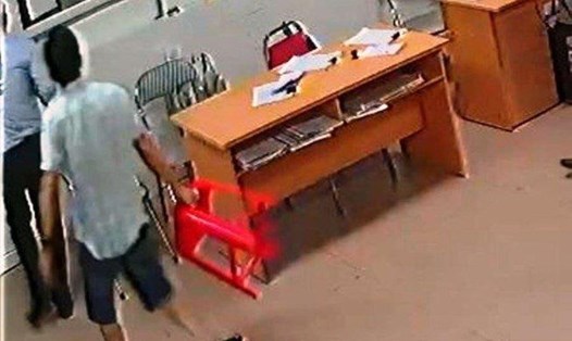 Ông Nguyễn Xuân Huân cầm ghế nhựa trong phòng cấp cứu. Ảnh cắt từ clip