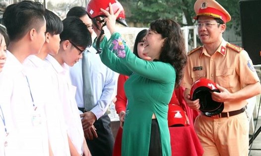 Thứ trưởng Bộ GDĐT Nguyễn Thị Nghĩa tặng mũ bảo hiểm cho sinh viên. Ảnh: Bảo Long