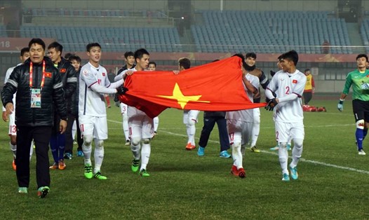 Các cầu thủ cầm lá cờ Việt Nam ăn mừng sau khi 90 phút thi đấu kết thúc. Ảnh: Hữu Phạm 