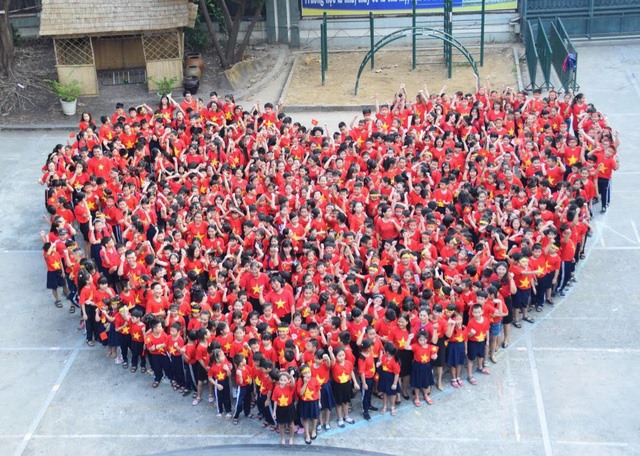 Học sinh mặc áo cờ đỏ sao vàng, xếp hình trái tim để cổ vũ U.23 Việt Nam. Ảnh: Dân Trí