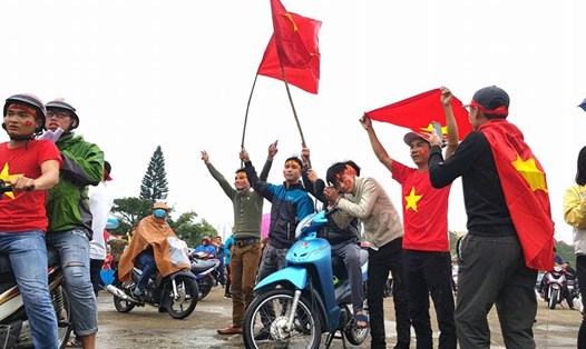 Người dân TP.Đồng Hới (Quảng Bình) đội mưa trong sắc đỏ sao vàng cổ vũ đội tuyển U23 Việt Nam chiều 27.1. Ảnh: Lê Phi Long
