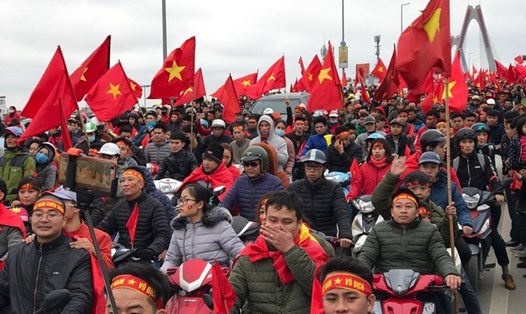 Trên cầu Nhật Tân, hàng ngàn người đổ ra chào đón đoàn xe chở đội tuyển. Ảnh: Ngô Phong 
