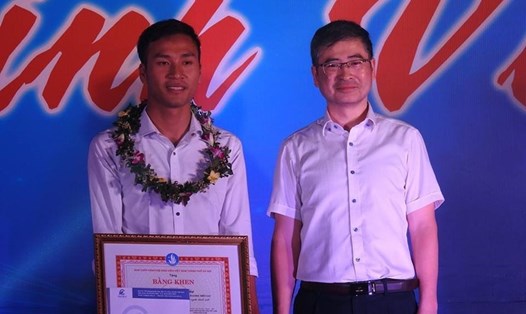 Em Vũ Huy Cảng (bìa trái) được Hiệu trưởng Đại học Điện lực Trương Huy Hoàng tặng thưởng vào ngày 25.10.