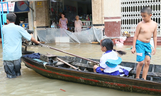 Mỗi ngày, các em học sinh ở phường Bình Thủy, quận Bình Thủy, TP.Cần Thơ được phụ huynh dùng thuyền đưa đi học một cách hết sức khó khăn. Ảnh: BT