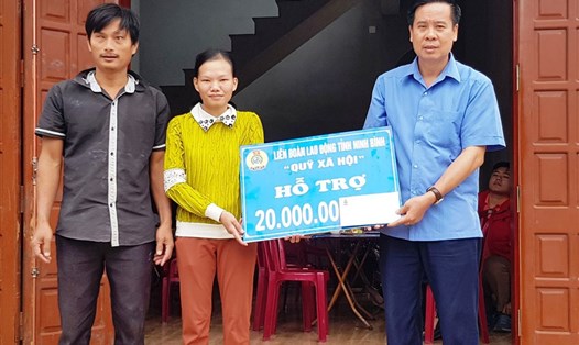 Đại diện lãnh đạo LĐLĐ tỉnh Ninh Bình trao tiền hỗ trợ cho gia đình chị Lương Thị Thanh Quế. Ảnh: NT
