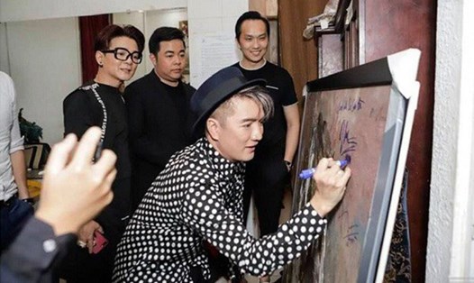 Các nghệ sĩ bên bức tranh của họa sĩ Hứa Thanh Bình. Ảnh: DUY ANH