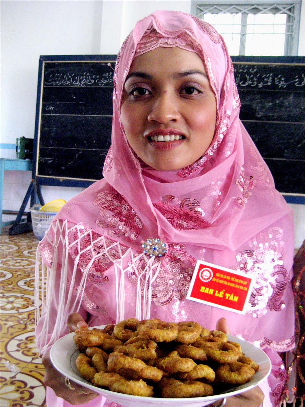 Cô gái Chăm với món bánh ngọt nổi danh. Ảnh: Lục Tùng