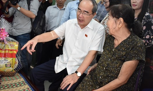 Bí thư Thành ủy TPHCM Nguyễn Thiện Nhân ân cần thăm hỏi gia đình bà Em. 