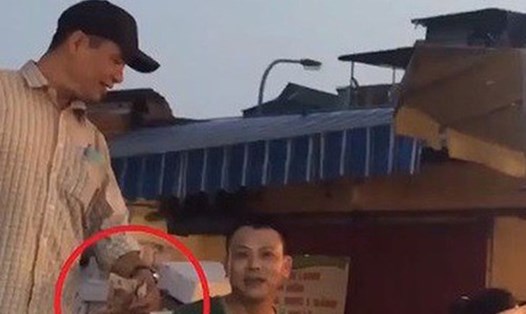 Công khai nhận tiền bảo kê ở chợ Long Biên. Ảnh: Cắt từ video VTV.
