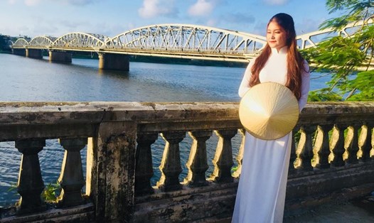 Hình ảnh nữ sinh trong tà áo dài bên cạnh cầu Trường Tiền từ lâu đã trở thành biểu tượng rất riêng của xứ Huế. Ảnh: PĐ.