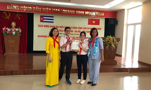 Bà Nguyễn Mỹ Hảo - Hiệu trưởng trường THCS Nghĩa Tân, Hà Nội - cùng các học sinh đón nhận lưu niệm từ đoàn đại biểu Đảng cộng sản Cuba.
