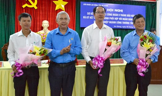 Chủ tịch LĐLĐ tỉnh An Giang Nguyễn Thiện Phú (thứ 2 trái sang) tặng hoa cho đại diện đơn vị, doanh nghiệp ký phối hợp. Ảnh: LT