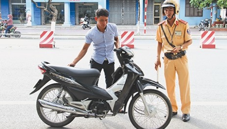 Lực lượng CSGT xử lý người đi xe máy không đội MBH. Ảnh: MH