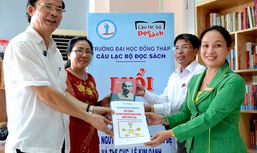 Gia đình nhà giáo  Nguyễn Văn Đệ  thực hiện nghi thức bàn giao tủ sách cho đại diện Ban chủ nhiệm CLB Đọc sách ĐHĐT. Ảnh: Lục Tùng