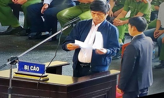 Bị cáo Nguyễn Thanh Hóa được xem lại các văn bản đã ký tại tòa. Ảnh Cao Nguyên.
