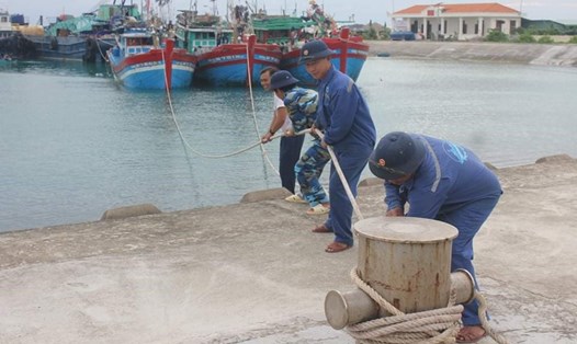 Cán bộ, nhân viên Trung tâm HC-KT Đảo Sinh Tồn đang cố định dây buộc tàu cá.