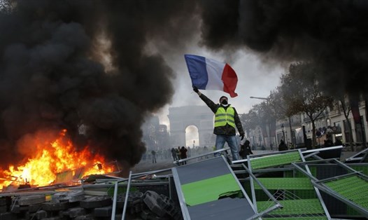 Một người biểu tình trên đại lộ Champs-Élysées, thủ đô Paris ngày 24.11. Ảnh: AP