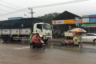 Người đàn ông bị tai nạn tử vong dưới trời mưa bão, người dân mang ô ra che thi thể.