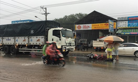 Người đàn ông bị tai nạn tử vong dưới trời mưa bão, người dân mang ô ra che thi thể.