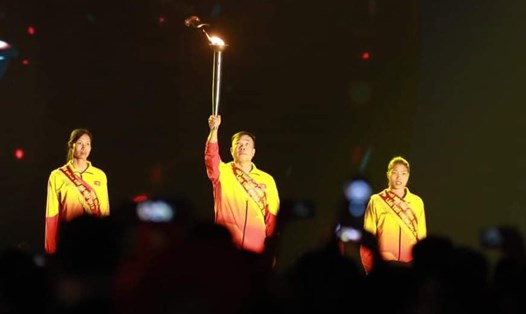 Xạ thủ Hoàng Xuân Vinh và các VĐV tiêu biểu thực hiện nghi lễ thắp đài lửa đại hội. Ảnh: VGP
