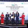Ông Vũ Tiến Lộc, Chủ tịch VCCI, trao bằng khen và hoa cho đại diện Nestlé Việt Nam.