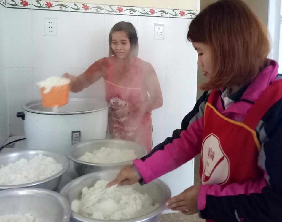 Giáo viên và nhân viên Y tế Trường Mầm non A Túc vừa làm công tác chuyên môn vừa tranh thủ nấu ăn cho trẻ. Ảnh: TH.
