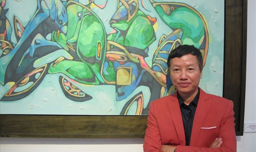 Họa sĩ Nguyễn Hữu Khoa bên tác phẩm tại triển lãm "Motorbikes" tại Hà Nội. Ảnh: L.Q.V