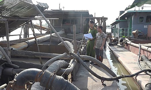 Tổ công tác kiểm tra, lập biên bản xử lý 2 tàu khai thác cát trái phép trên sông Phả Lại. Ảnh: Xuân Tân.