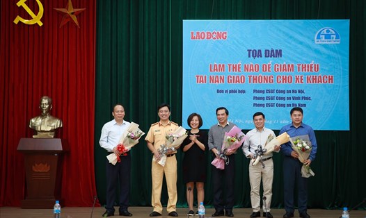 Phó Tổng biên tập báo Lao Động Phan Thu Thủy tặng hoa cho các khách mời tham dự tọa đàm. Ảnh: Hải Nguyễn