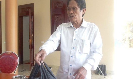 "Thần y" Trần Văn Phú với túi thuốc trên tay đưa cho bệnh nhân